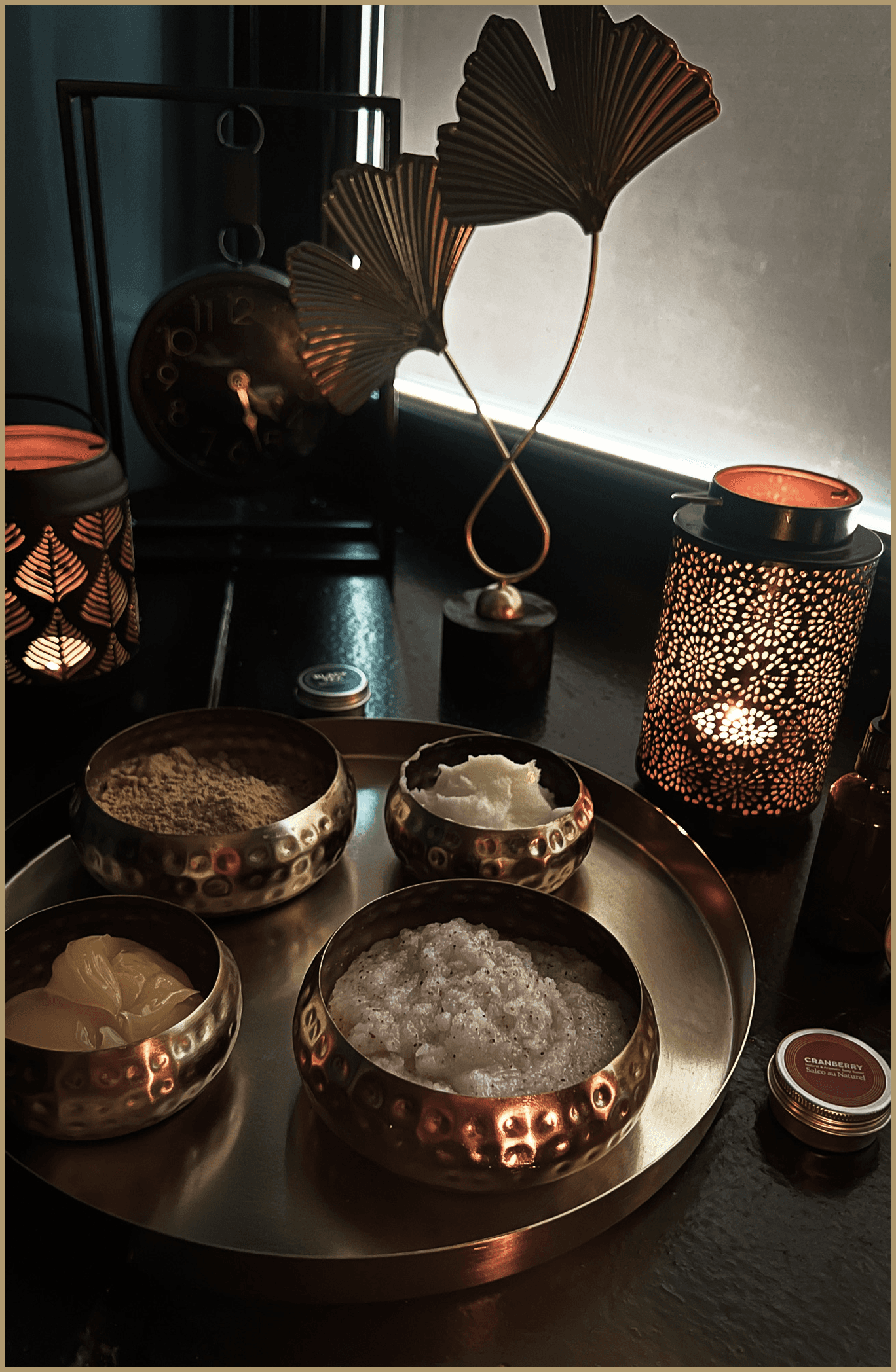 Copper bowls with spa treatments on a tray with decorative lighting